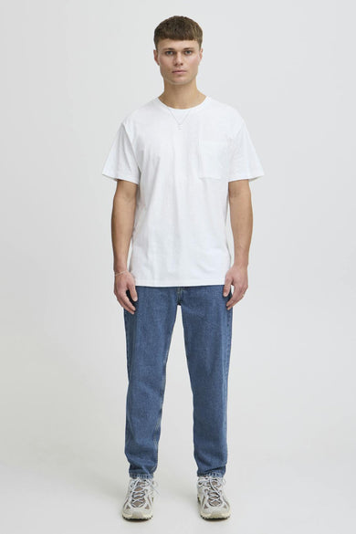 Jean droit mi-bleu denim de SOLID, porté avec un T-shirt blanc et des baskets blanches.
