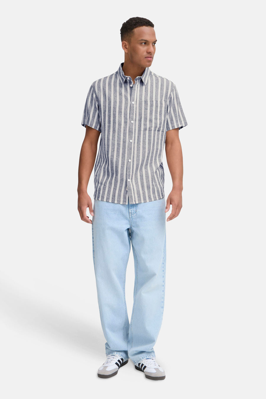 Blauw gestreept overhemd van SOLID, met korte mouwen en gedragen met lichtblauwe jeans en witte sneakers.