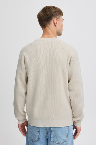 Pull écru avec col rond de SOLID, à structure en losange, associé à un jean bleu clair.