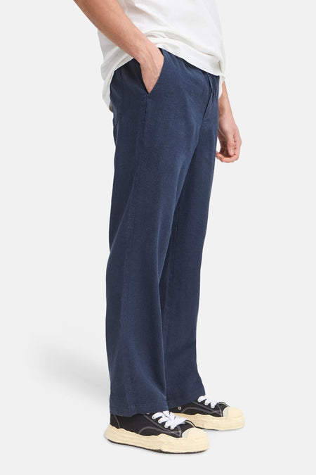 Blauwe broek van SOLID, met steekzak en veter, gedragen met sneakers.