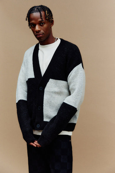 Zwart gilet van SOLID, met contrasterende vlakken en een geknoopte sluiting, gedragen over een wit shirt.

