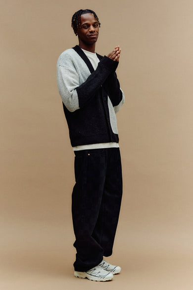 Zwart gilet van SOLID, gedragen over een wit shirt en met zwarte corduroy broek en sneakers.
