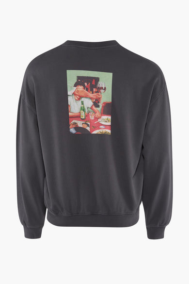 Zwarte sweater van SOLID, met een afbeelding van een gezelschap aan een tafel op de achterkant.
