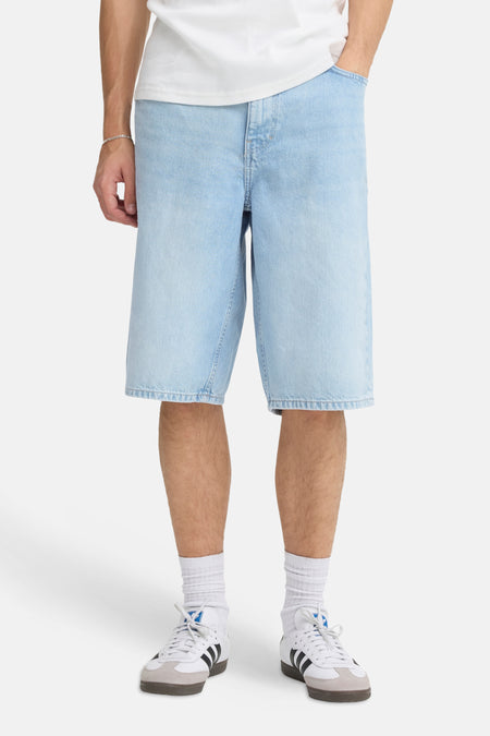 Lichtblauwe denim short van SOLID met wijde pasvorm, gedragen met een wit T-shirt en sneakers.