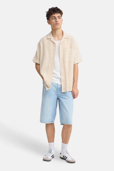 Lichte blauwe denim short van SOLID, gedragen door een man met een beige overhemd en witte sneakers.