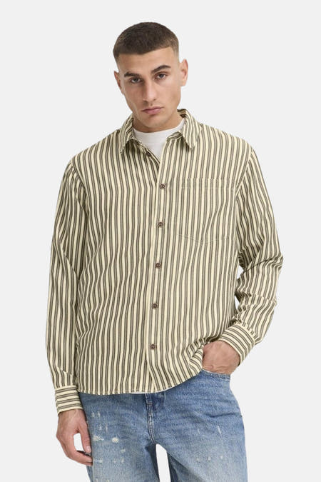 Chemise écru à manches longues de SOLID, avec des rayures verticales et une fermeture à boutons, associée à des jeans et des chaussures.