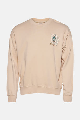 Ecru sweater van SOLID, met een print van speelkaarten op de borst.
