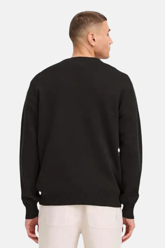 Pull noir à col rond de SOLID, vu de l'arrière, associé à un pantalon crème.