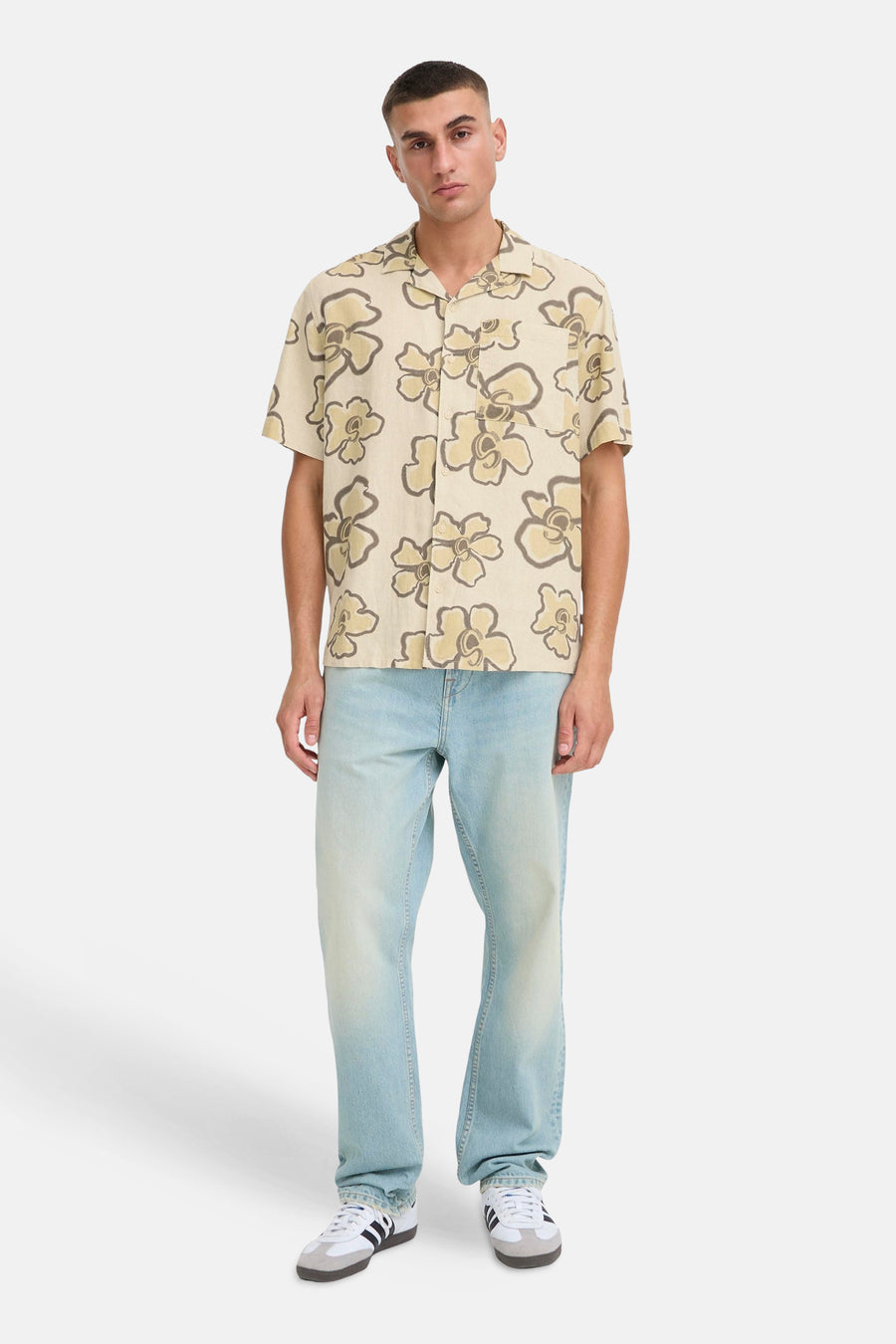 Chemise beige à manches courtes de SOLID, avec motif floral et portée avec un jean bleu et des baskets.