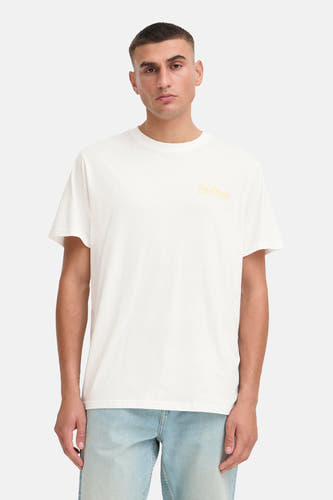 T-shirt blanc à manches courtes de SOLID avec une impression jaune. L'ensemble est complété par un jean bleu clair et des baskets.