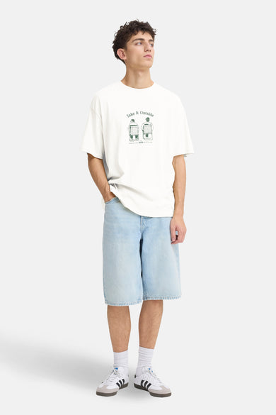 Wit T-shirt met korte mouwen van SOLID, met groene print op de borst, gecombineerd met denim shorts en witte sneakers.
