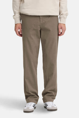 Bruine chino van SOLID, met rechte pijpen en gedragen met een beige sweatshirt en witte sneakers met strepen.

