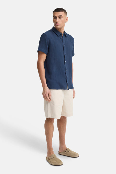 Blauw overhemd met korte mouwen van SOLID, van gestructureerde stof, gecombineerd met een beige short en suède clogs.