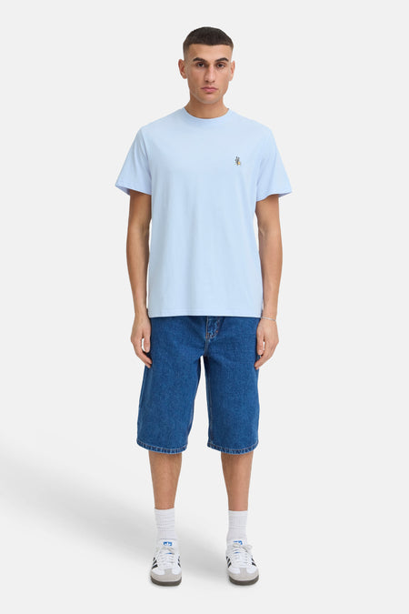 Blauw T-shirt met korte mouwen van SOLID, met geborduurde cactus en zon op de borst, gedragen met denim shorts.