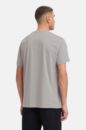 T-shirt à manches courtes gris clair de SOLID, porté par un homme debout vu de dos, avec un pantalon noir et un bracelet argenté.
