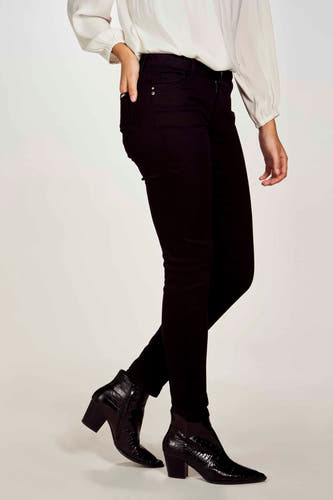 Pantalon noir de Morgan De Toi, associé à une blouse blanche et des bottines noires avec un motif crocodile.