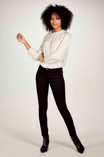 Pantalon noir de Morgan De Toi, associé à une blouse blanche et des bottes noires.