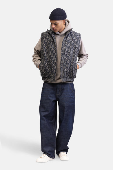 Beige sweater met kap van Redefined Rebel, gedragen met een vest met patroon, wijde jeans en witte sneakers.