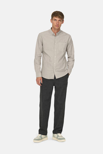 Chemise taupe à longues manches de ONLY & SONS®, portée avec un pantalon foncé et des baskets crème.