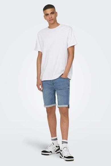 Lichtblauwe denim jeansshort van ONLY & SONS, met opgerolde pijpen en witte sokken met strepen en sportschoenen.
