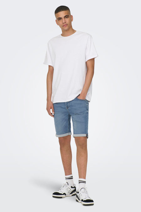 Jean court en denim bleu clair de ONLY & SONS, avec des poches rabattues et des chaussettes blanches à rayures et des baskets.