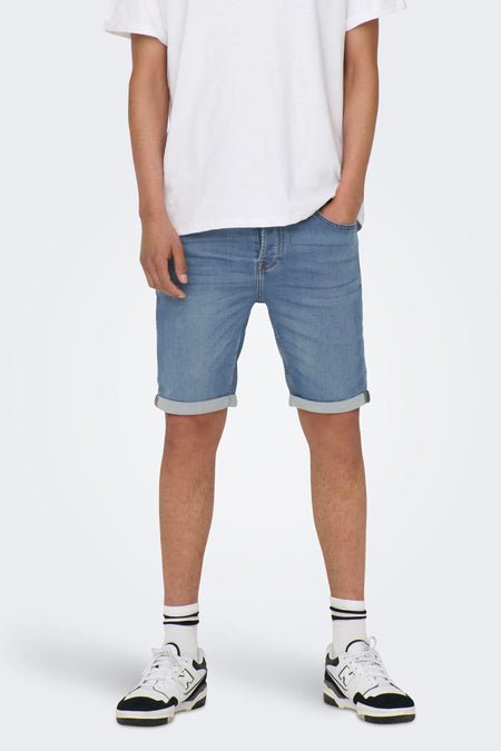 Jean court en denim bleu clair d'ONLY & SONS, avec des poches froncées, porté avec un T-shirt blanc et des sneakers avec des chaussettes.