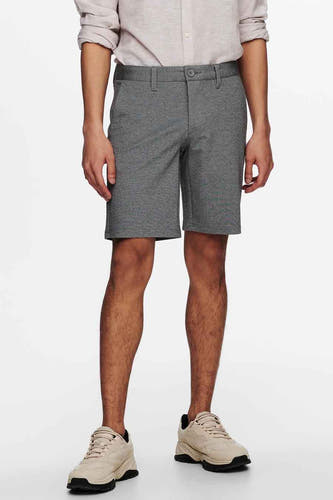 Veste grise d'ONLY & SONS, avec poches et fermeture à bouton, associée à un chemisier gris clair et des baskets beige.