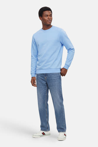 Blauwe sweater met ronde hals van ONLY & SONS®, gecombineerd met jeans en witte sneakers.