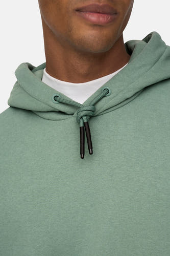 Pull-over vert de ONLY & SONS avec capuche, avec des boutons-pression noirs, porté sur un T-shirt blanc.