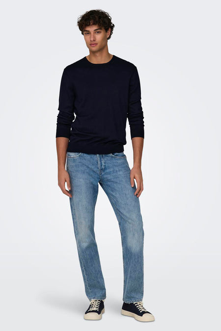 Pull bleu à col rond de ONLY & SONS®, porté par un homme avec un jean clair et des baskets foncées.