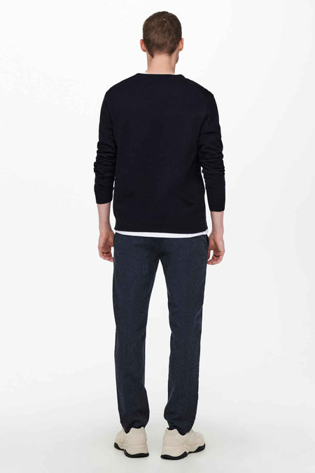 Blauwe trui met ronde hals van ONLY & SONS, van achteren gezien op een man met een wit ondershirt, donkere broek en lichte sneakers.
