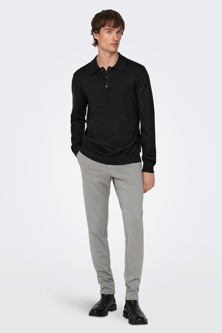 Zwarte trui van ONLY & SONS®, met lange mouwen, gecombineerd met grijze broek en zwarte laarzen.