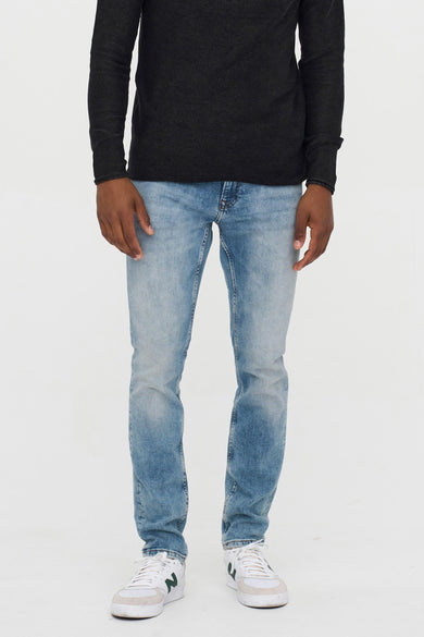 Lichtblauwe slim-fit jeans van ONLY & SONS®, met gewassen denimtextuur, gedragen met donkere trui en witte sneakers, front view.