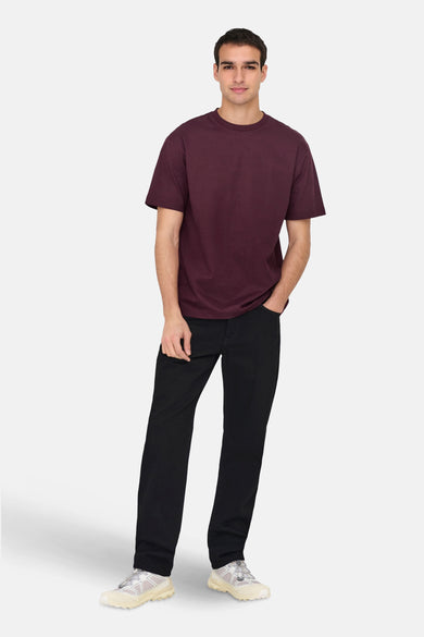 T-shirt Bordeaux à manches courtes de ONLY & SONS, porté avec des jeans noirs et des baskets blanches.