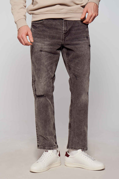 Donkergrijze tapered jeans van ONLY & SONS, met distressed details en gecombineerd met witte sneakers.

