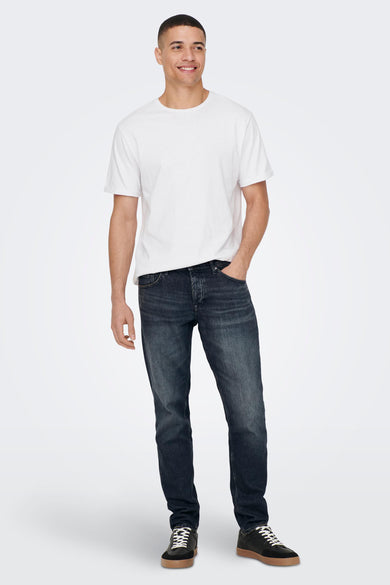 Tapered jeans van donkergrijs denim van ONLY & SONS, gedragen met een wit T-shirt en zwarte sneakers.