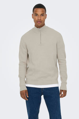 Ecrukleurige pull met rolkraag van ONLY & SONS, met een halfopen ritssluiting, gedragen met een spijkerbroek en wit T-shirt.
