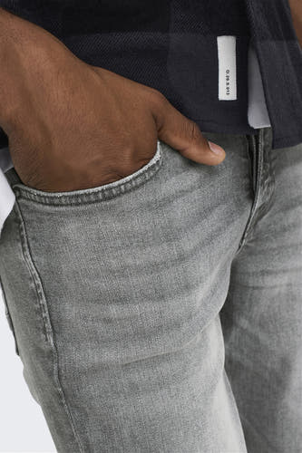 Grijze slim fit jeans van ONLY & SONS, met steekzak en hand in broekzak.