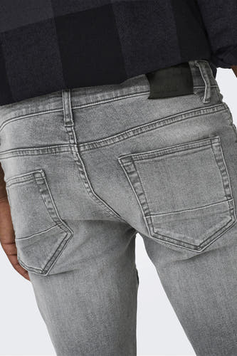 Jean slim fit en denim gris moyen de ONLY & SONS, avec poches arrière et passants de ceinture, combiné avec une chemise à carreaux.