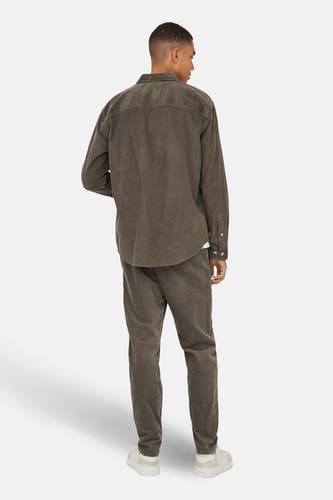 Bruin corduroy overhemd van ONLY & SONS, met lange mouwen en een casual pasvorm, gecombineerd met bijpassende corduroy broek en witte sneakers.