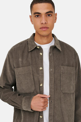 Bruin hemd van ONLY & SONS, gedragen over een wit T-shirt, met borstzakken en knoopsluiting.