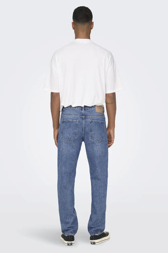 Jean bleu large d'ONLY & SONS, avec une coupe décontractée et des baskets noires.