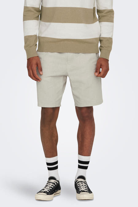 Short gris d'ONLY & SONS, associé à un pull rayé, des chaussettes blanches avec des rayures noires et des sneakers noires.