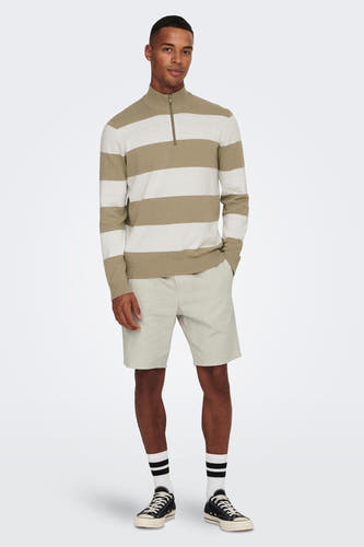 Grijze short van ONLY & SONS, met shorts en zwarte sneakers met witte sokken.
