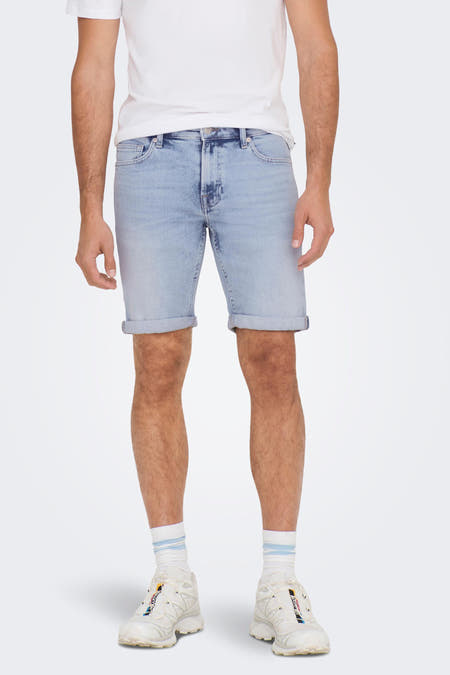 Short de jeans denim bleu clair d'ONLY & SONS, avec des jambes retroussées, combiné avec un t-shirt blanc et des baskets blanches.