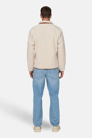 Ecru korte jas van ONLY & SONS®, met lange mouwen, geribbelde kraag en blauwe jeans.
