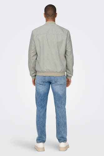 Beige jas van ONLY & SONS®, met lange mouwen en details van denim jeans en crème schoenen.
