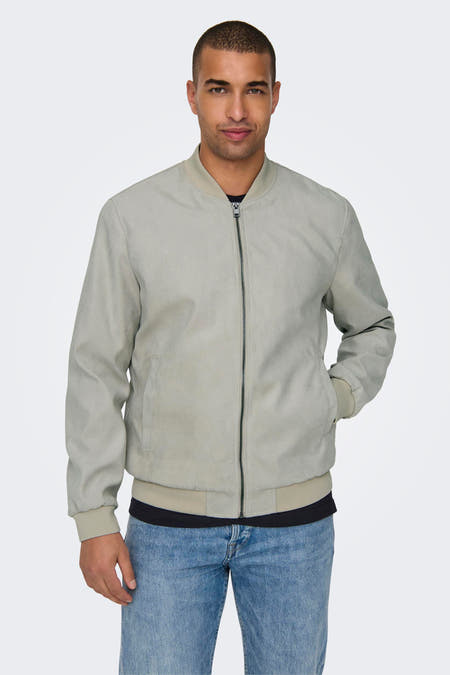 Manteau court beige de ONLY & SONS, avec une fermeture éclair et porté sur un t-shirt noir et des jeans bleus.