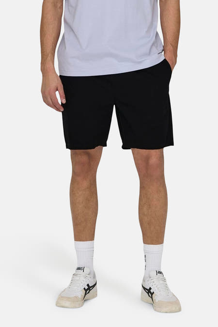 Zwarte short van ONLY & SONS, met witte sokken en Asics schoenen.