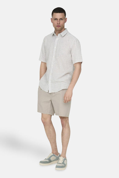 Pantalon court beige de ONLY & SONS®, associé à un chemisier rayé à manches courtes et des baskets bleu clair.